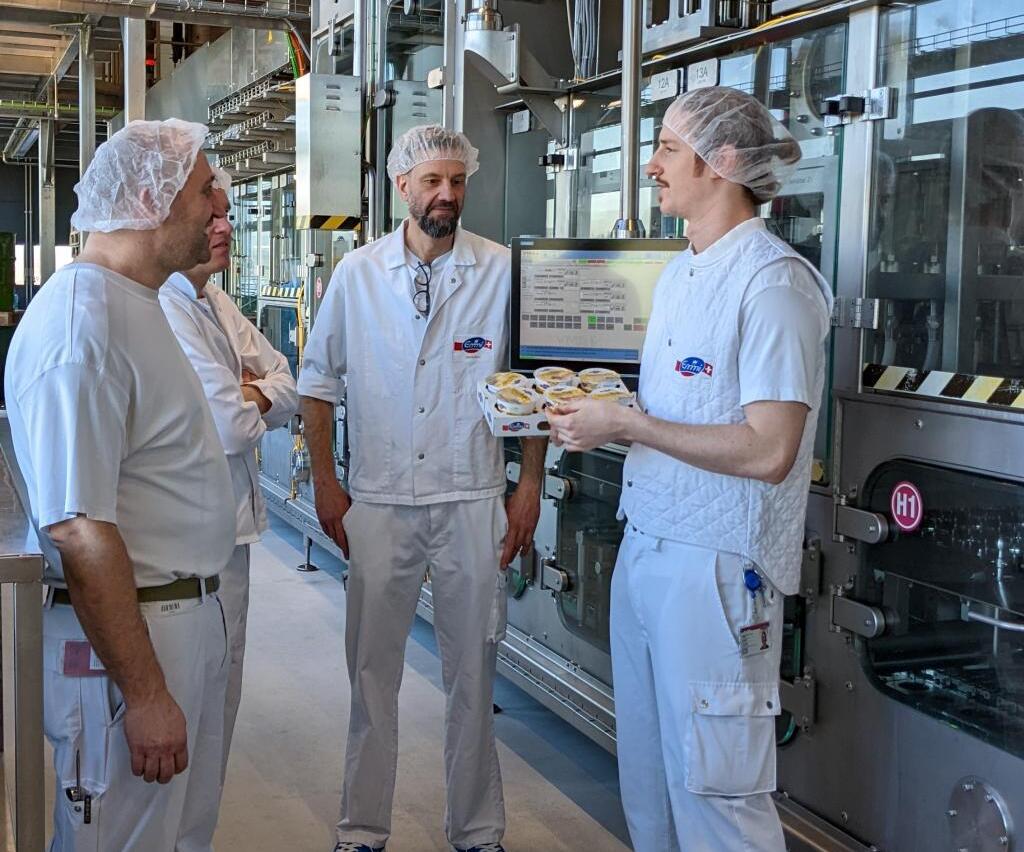 René Imholz (rechts )zusammen mit drei seiner Teammitglieder vor einer grossen Abfüllanlage. Foto: zVg