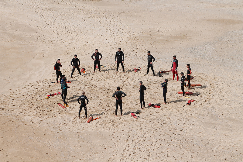 Gruppe Taucher steht im Sand.