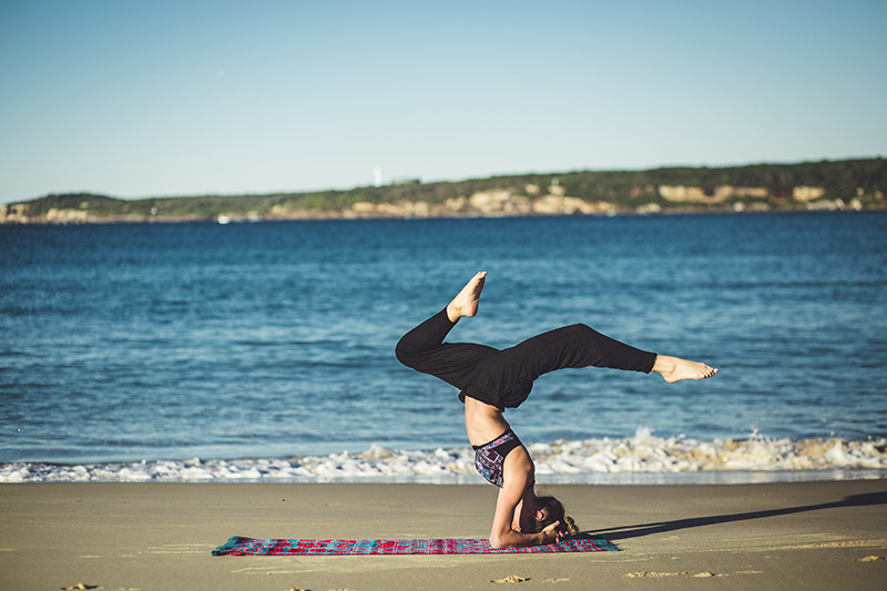 Frau macht Yoga am Meer.