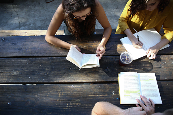 Frauen lesen in Büchern und schreiben.